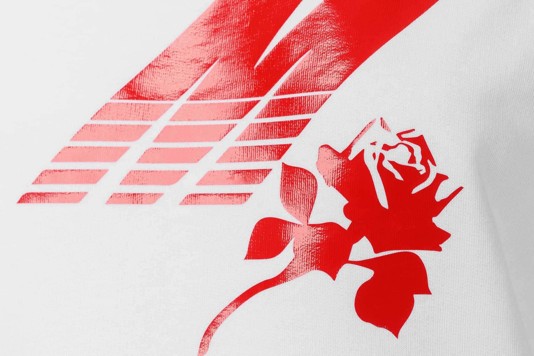 Primer plano de una estampación roja sobre camiseta blanca, con el degradado escalonado y la trama del tejido visible bajo la tinta